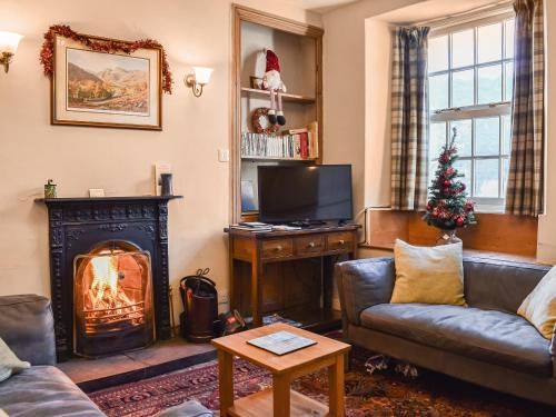een woonkamer met een open haard en een kerstboom bij Lingmoor View in Ambleside