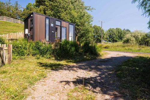 een klein huisje aan de kant van een weg bij Stour Cabin by Tiny Away in Huiroa