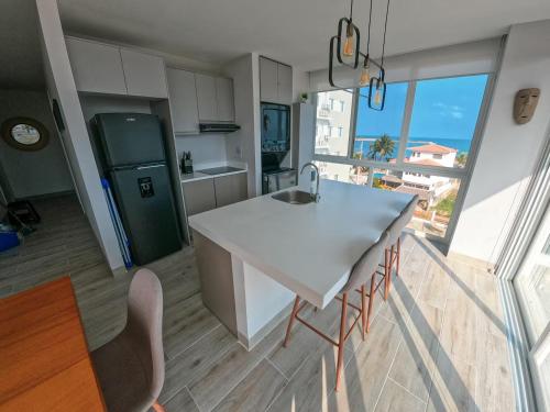 a kitchen with a white counter and a large window at Brand New!! Cozy Beachfront Apartment in Punta Blanca