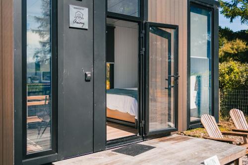 een kamer met een bed in een huis bij Avon Cabin by Tiny Away in Huiroa