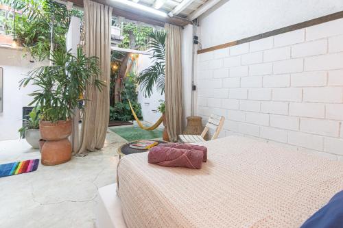 a bedroom with a bed in a room with plants at Casa Azul Tropical House by Xarm Apartments in Santa Marta