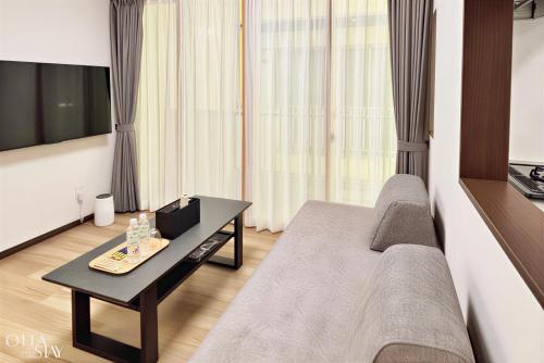 a living room with a couch and a table at Oita Stay Inn Miyakomachi in Oita