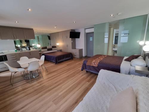 a large hotel room with two beds and a kitchen at Melbourne ViVo in Melbourne