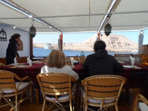 een groep mensen aan een tafel op een boot bij Dongolah Boat Abu Simbel in Tunqālah