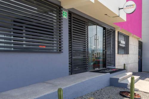 a building with a window with blinds on it at Hotel Estancias VIVE MX el marques Queretaro, Trademark in Hércules