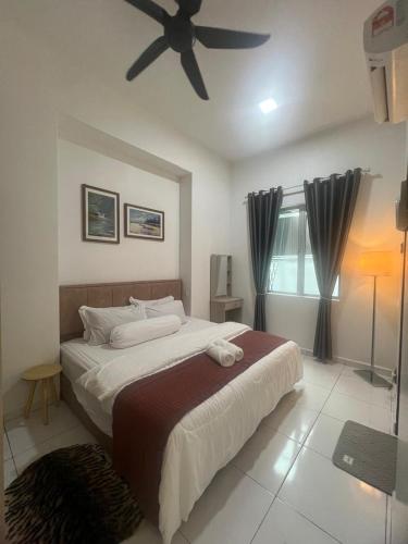 Un dormitorio con una cama grande con ventilador de techo. en Kj Resident Homestay, en Alor Setar