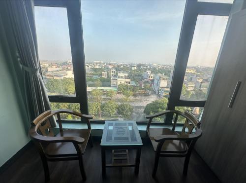 a table and two chairs in front of a window at Hotel Hoàng Lê Tiền Hải in Tiền Hải