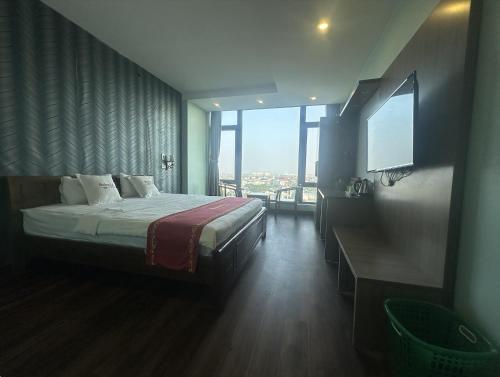 a bedroom with a bed and a large window at Hotel Hoàng Lê Tiền Hải in Tiền Hải