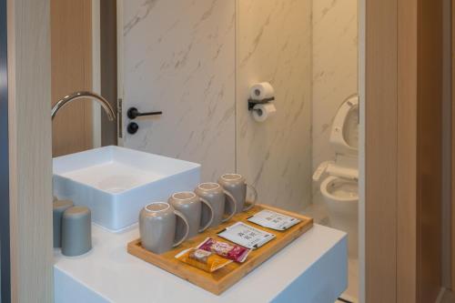 ein Badezimmer mit Waschbecken und einem Tablett mit Tassen in der Unterkunft 森山寫照 in Dongshan