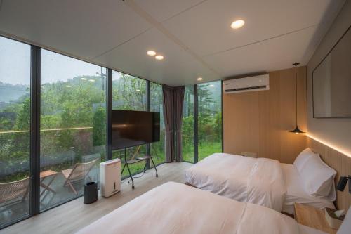 ein Schlafzimmer mit zwei Betten und einem großen Fenster in der Unterkunft 森山寫照 in Dongshan
