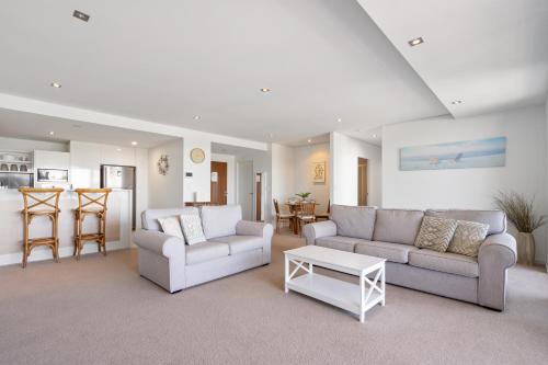 a living room with two couches and a table at Waterline 202 in Forster