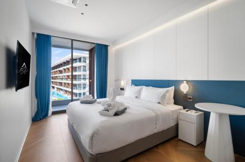 een slaapkamer met een groot wit bed en een tafel bij Premier Kora 3-Bedroom Apartment E333 Beachfront in Layan Beach