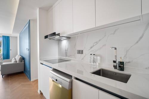 een witte keuken met een wastafel en een aanrecht bij Premier Kora 3-Bedroom Apartment E333 Beachfront in Layan Beach