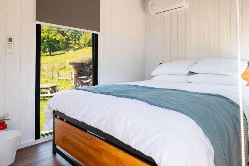 HuiroaStone Cabin by Tiny Away的一间卧室，配有一张大床和一扇窗户。