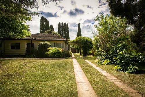 a house with a grass yard with a house at Violet's cottage in Bowral