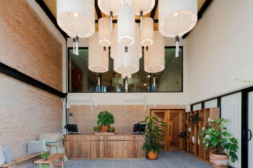 a lobby with a brick wall and a large chandelier at The Tribe Nimman Boutique Hotel in Chiang Mai