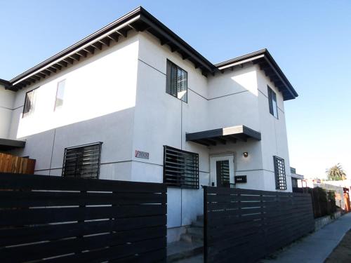 a white house with a black fence in front of it at Normandie Good Vibes Only in Los Angeles