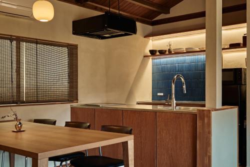 a kitchen with a sink and a wooden table at 千日箱根 SEN-NICHI Hakone 大涌谷を望む絶景宿 in Hakone