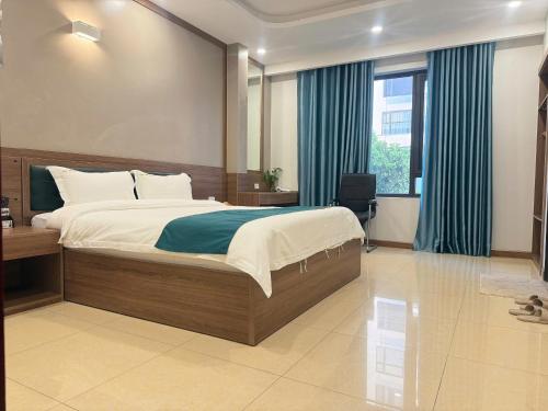 Schlafzimmer mit einem großen Bett und blauen Vorhängen in der Unterkunft Phương Anh Villa Pro in Bắc Ninh