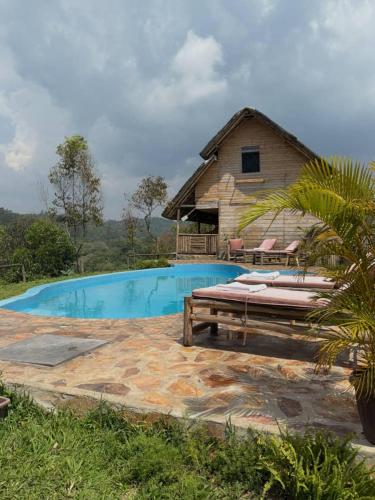 a swimming pool in front of a house at Nyanja View Resort in Fort Portal