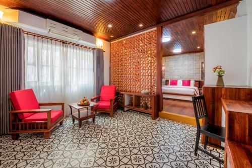 a room with red chairs and a bed and a desk at SATTA Private Pool Grill & Chill Villa in Siem Reap