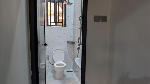 a bathroom with a toilet and a window at Danshome in Moshi
