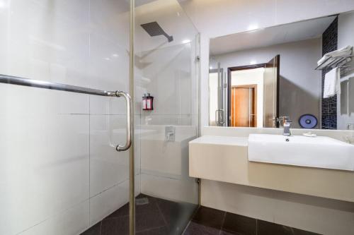 Un baño blanco con lavabo y ducha. en Kingston Hotel 18 - Kuala Lumpur Sri Damansara, en Kuala Lumpur