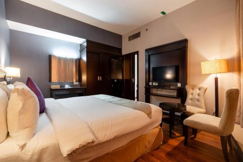 una habitación de hotel con una cama y un televisor en Kingston Hotel 18 - Kuala Lumpur Sri Damansara, en Kuala Lumpur