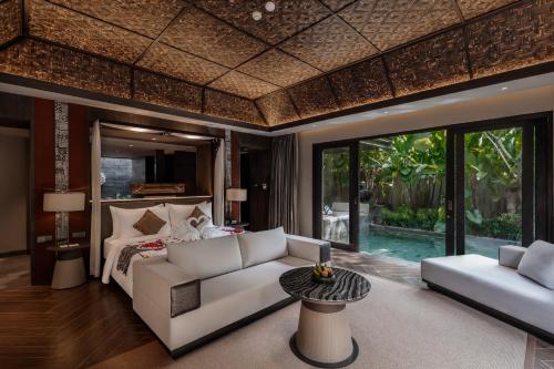 a living room with a white couch and a bed at Ayatara Resort Ubud in Payangan