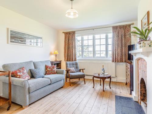 Una sala de estar con un sofá y una chimenea. en Mark Farmhouse, en Bradwell on Sea