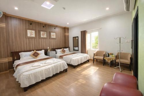 a hotel room with two beds and a chair at Phương Anh 7- Only accept Vietnamese customers in Danang