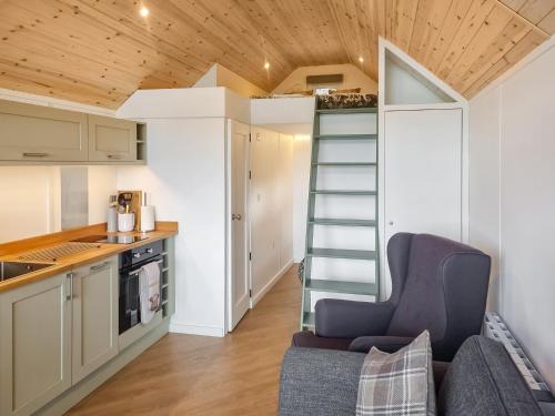 a tiny kitchen with a staircase in a tiny house at Tyan - Uk49354 in Gatebeck