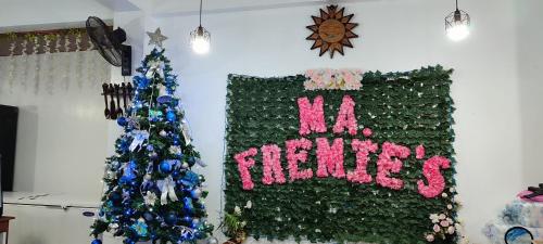 a green wall with a hello friday sign and a christmas tree at Ma Fremie Hometel in Lal-lo
