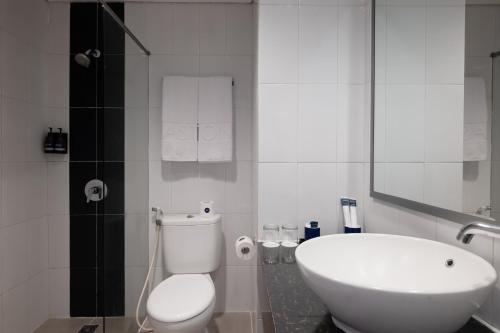 RembangにあるAston Inn Rembangのトイレと洗面台を備えた白いバスルーム