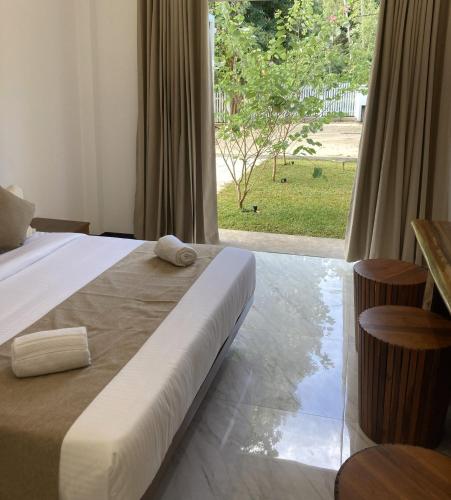 a bedroom with a bed and a large window at Ocean Edge Holiday Resorts in Hiriketiya