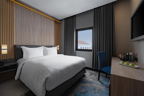 RembangにあるAston Inn Rembangの大きなベッドと窓のあるホテルの部屋