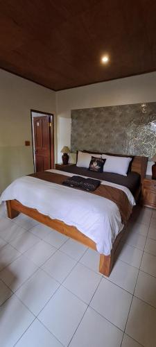 een slaapkamer met een groot bed in een kamer bij Serongga guest house in Lebih