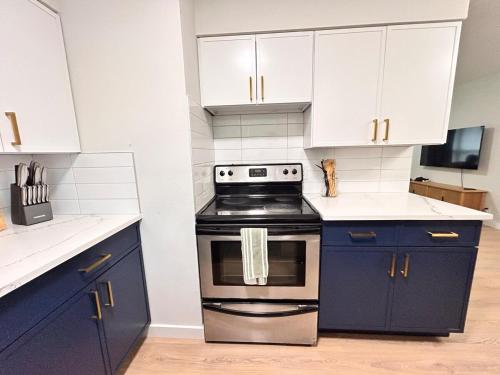 a kitchen with blue cabinets and a stove at Cozy Modern 3BR Escape - Sanford in Sanford