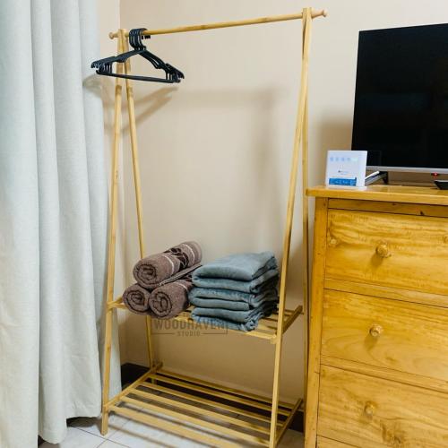 Ein Handtuchhalter mit Handtüchern darauf neben einer Kommode. in der Unterkunft Spacious Studio Unit at Albergo Residences Baguio in Baguio City