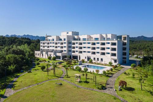 una vista esterna di un grande edificio con un parco di Dasan Bearchae Golf N Resort a Kangjin