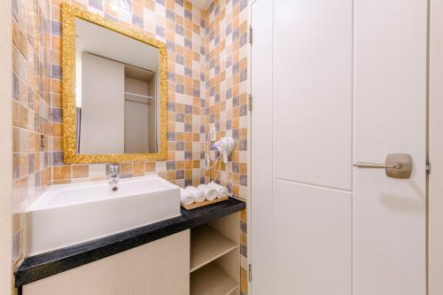 un bagno con lavandino e specchio di Cordelia Hotel a Seogwipo