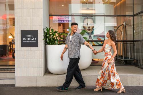 a man and woman walking in front of a store at Hotel Indigo Melbourne on Flinders by IHG in Melbourne