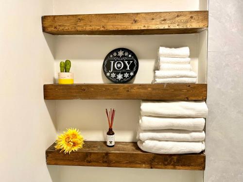 een plank met handdoeken en een klok aan de muur bij Private Entire Guest Suite, 1 min to bus stops to Downtown and major attractions in Vancouver