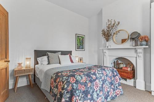 een slaapkamer met een bed en een open haard bij The Countess in Launceston