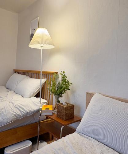 a bedroom with two beds and a lamp on a table at Spacious 2BR Apartment near Subway Free Parking Seoul in Seoul