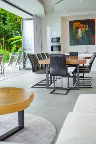 a dining room with wooden tables and chairs at Lapista 6 Bedroom Luxury Vila in Phuket