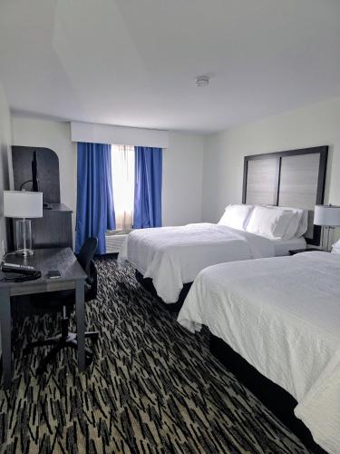 a hotel room with two beds and a desk at Garner Hotel Missoula Southwest by IHG in Missoula