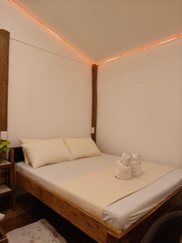 a bed in a room with white sheets and lights at Charity Pension House in San Vicente