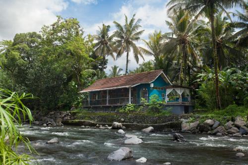 a house in the middle of a river at Darmada Eco Resort in Sidemen