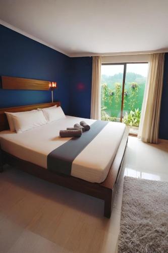 une chambre avec un grand lit avec une grande fenêtre dans l'établissement Windy's Leisure Villa, à Negombo